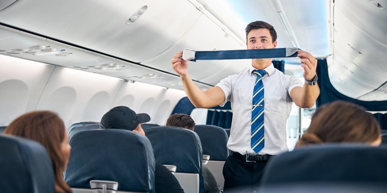 Flygvärd visar säkerhetsutrustning ombord på ett flygplan