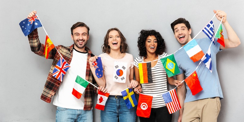 Young adults holding international flags, representing an international workforce