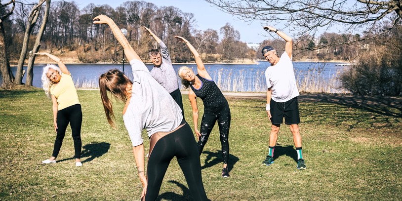 Elderly people doing gymnastics by a lake