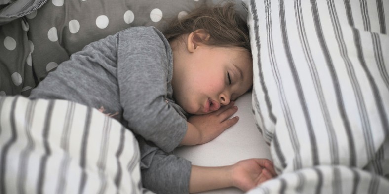 Sick child sleeping in bed