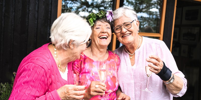 Three elderly women laughing together