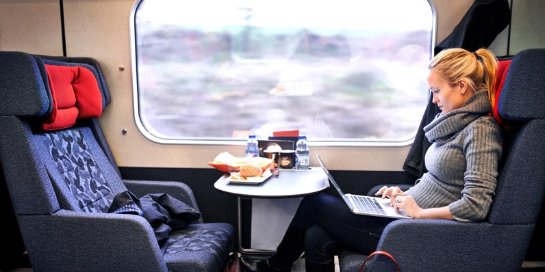 Commuter on a train working on a laptop