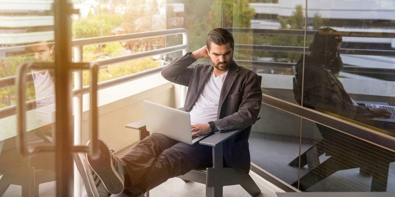 Man sitting with a laptop at an outdoor workplace
